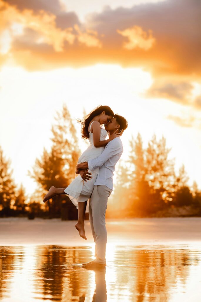 A romantic couple embraces on a beach at sunset in Ilha Comprida, Brazil.